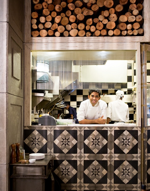 Mumbai commercial kitchen with smiling chef and wood stacks