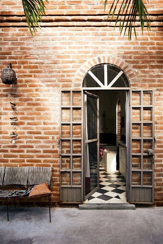 Beautiful entryway of brick house with black and white checkerboard tiles