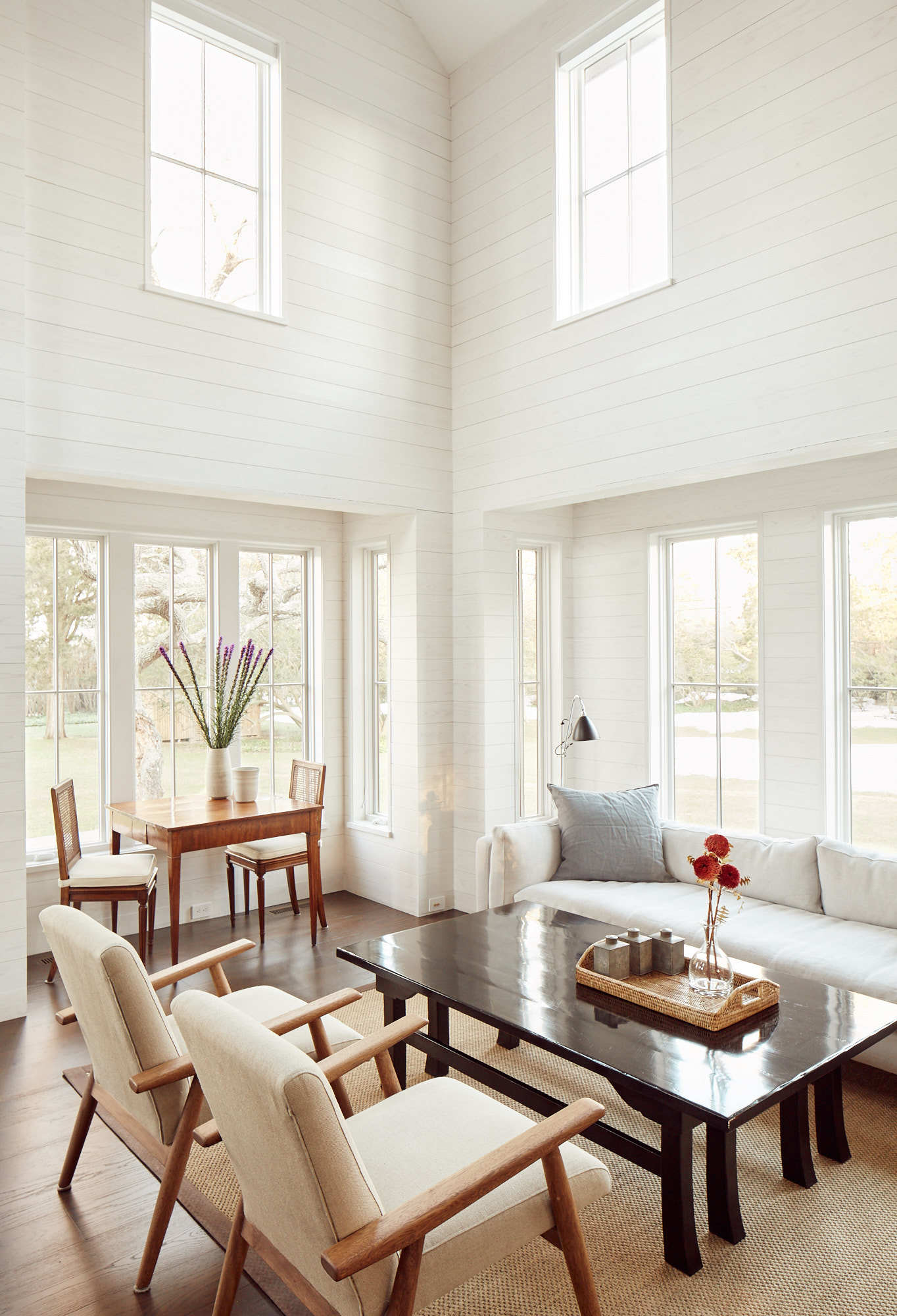 Modern lounge with white wood panels and tall ceilings for Wettling Architects