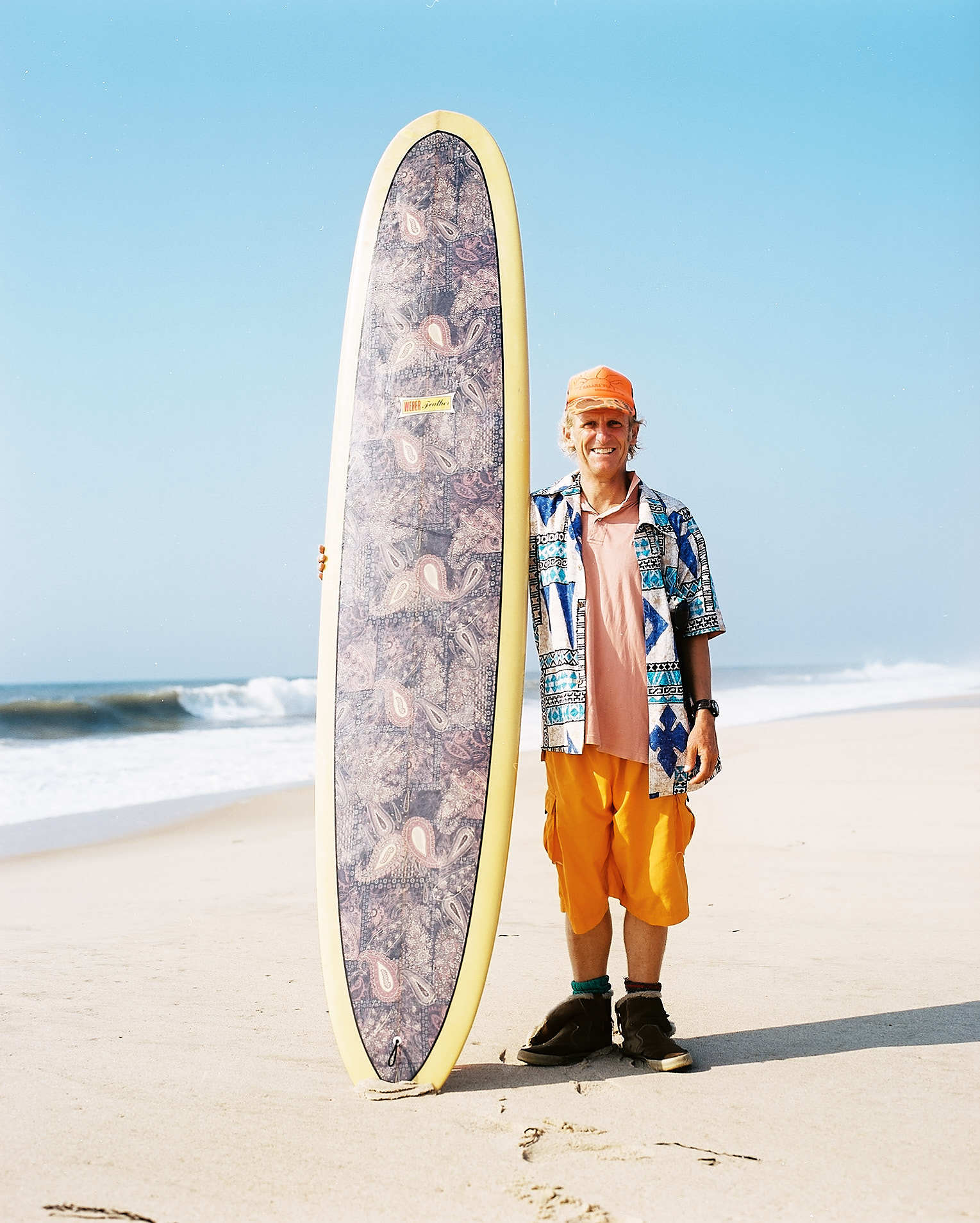 Portrait of surfer on beach with surfboard and colorful clothing