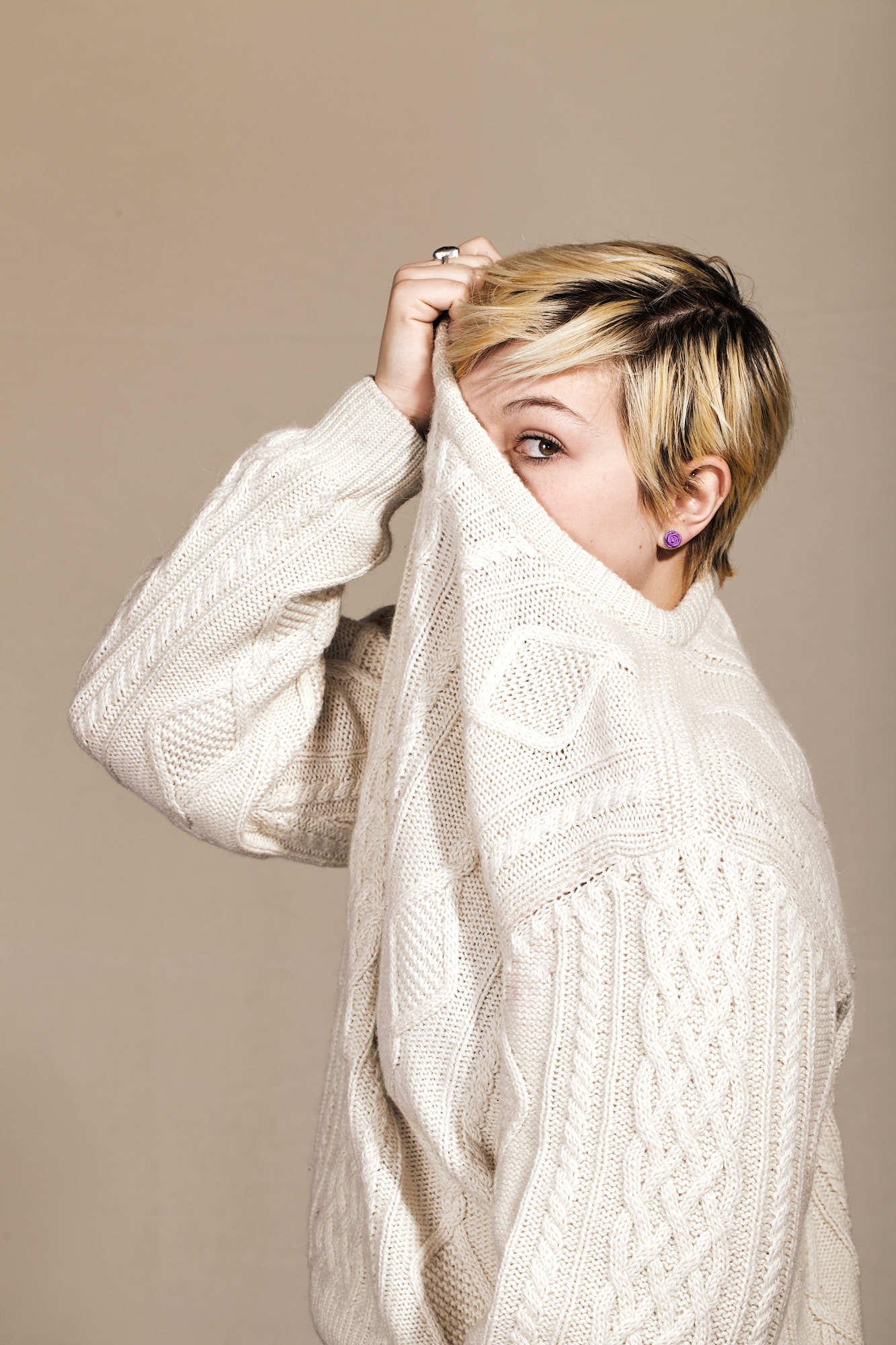 Editorial portrait of woman with short blonde hair wearing knitted sweater