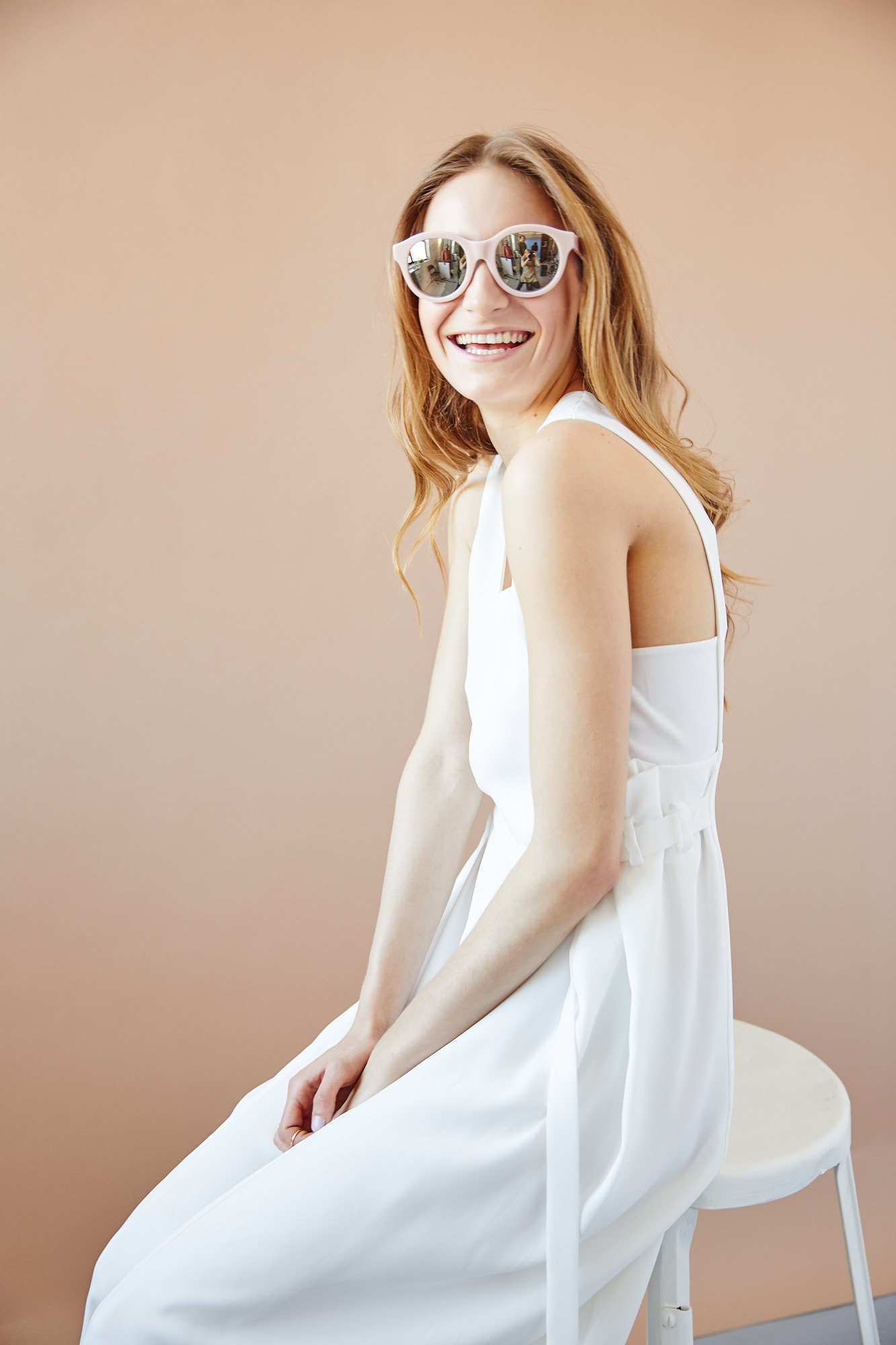 Strawberry blonde girl in oversized mirrored sunglasses and white dress