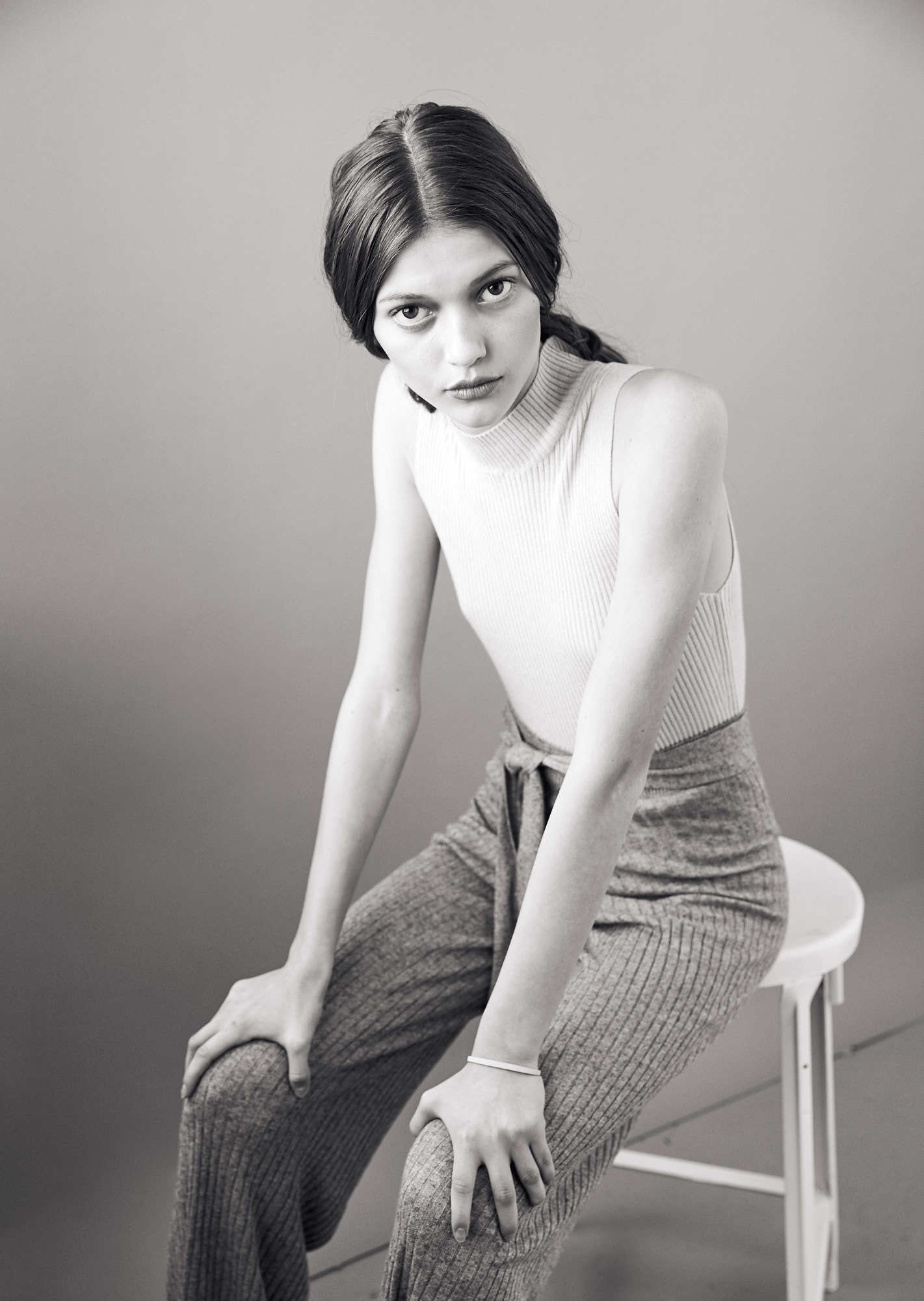 Black and white editorial photograph of girl wearing white ribbed turtleneck
