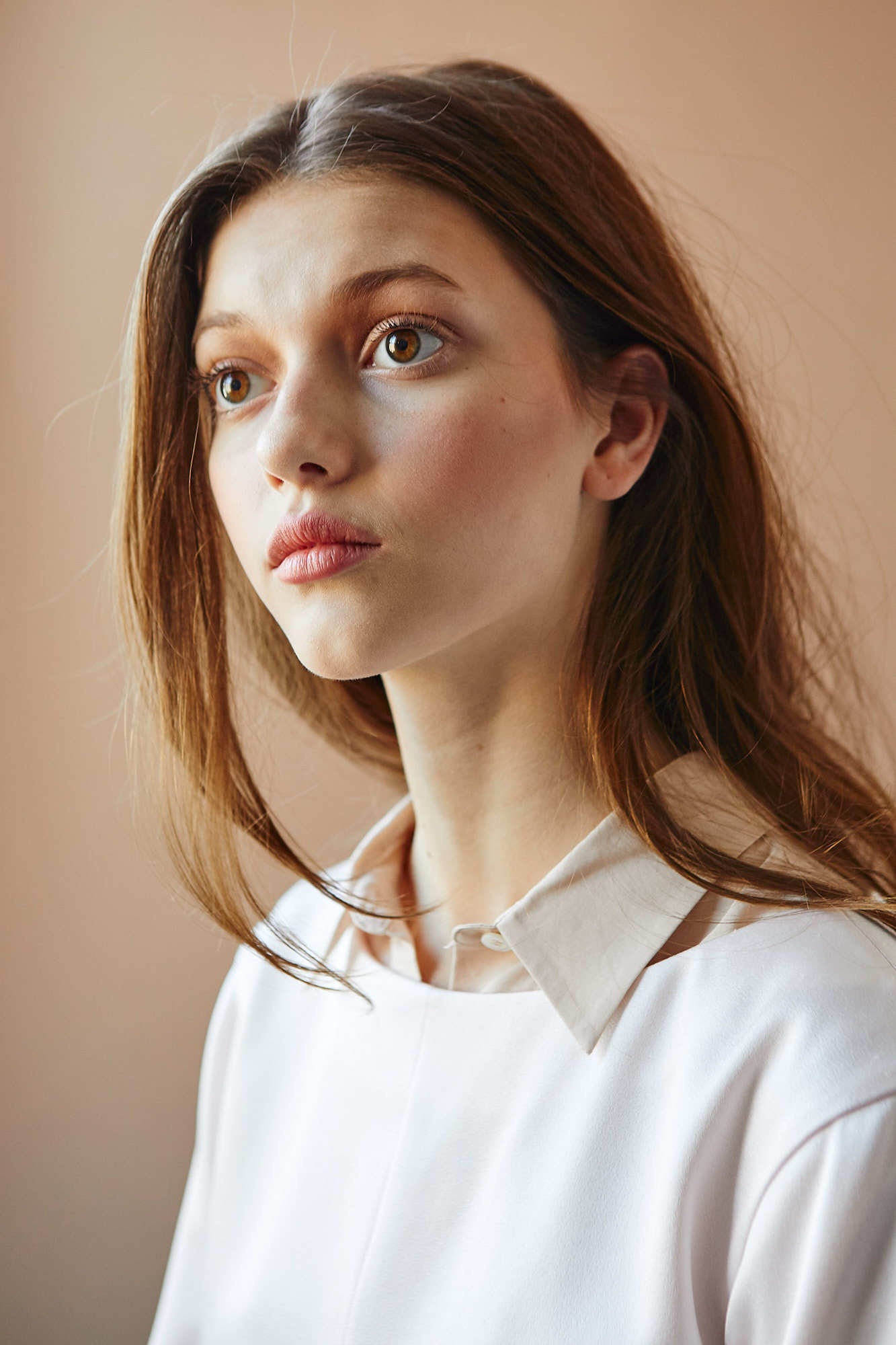 Editorial portrait of brunette girl with pink lipstick and pollo under shirt
