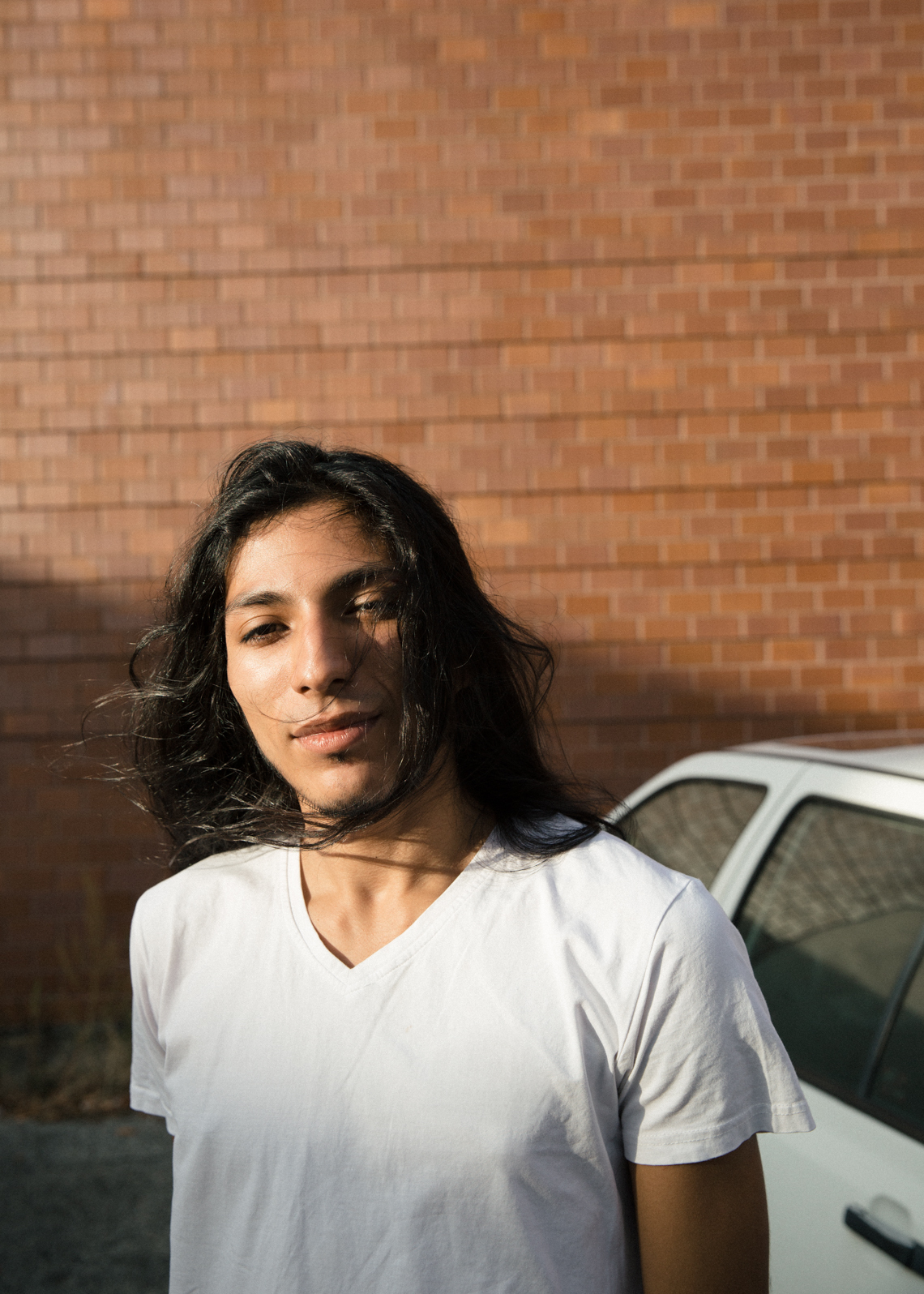 Young man with long black hair and white t-shirt