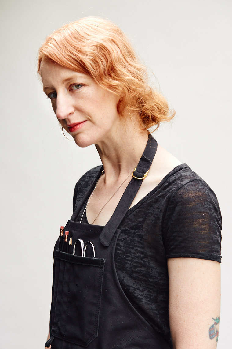 Female clothing designer with strawberry blonde hair and red lipstick