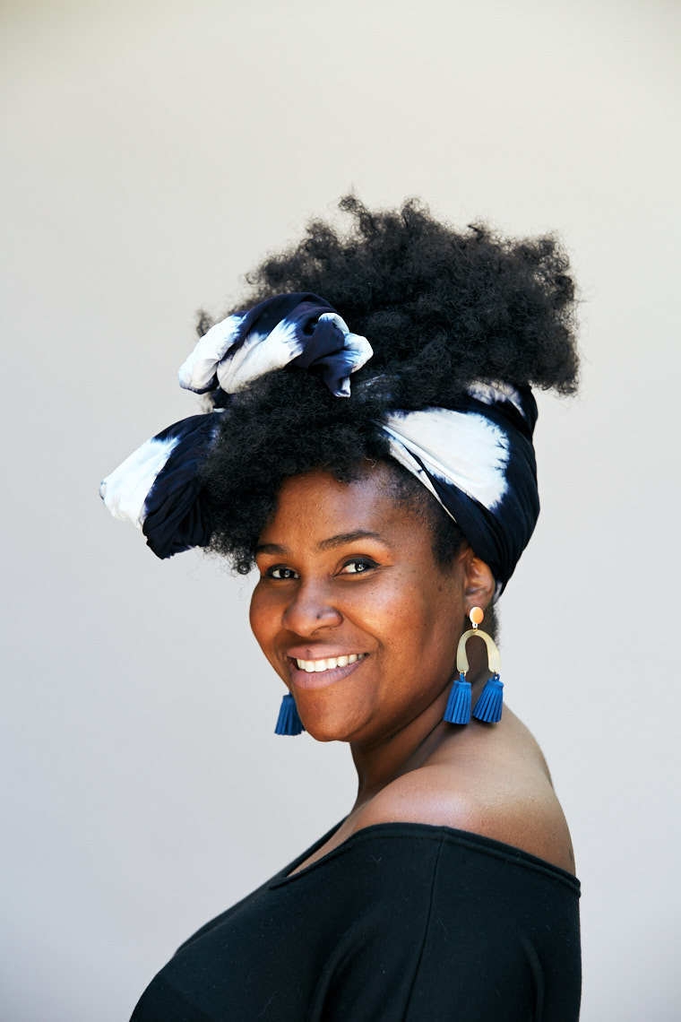 Beautiful black woman wearing head scarf and dangling blue earrings