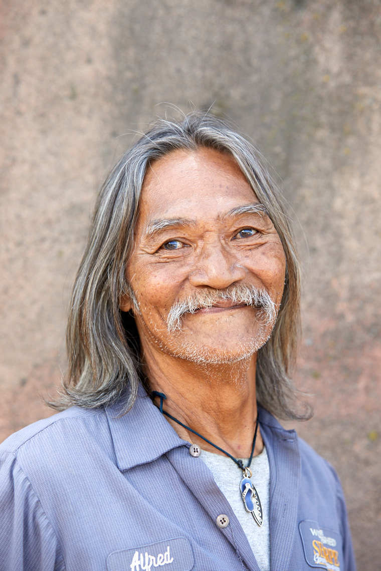 Smiling older man with long gray hair mustache and kind eyes