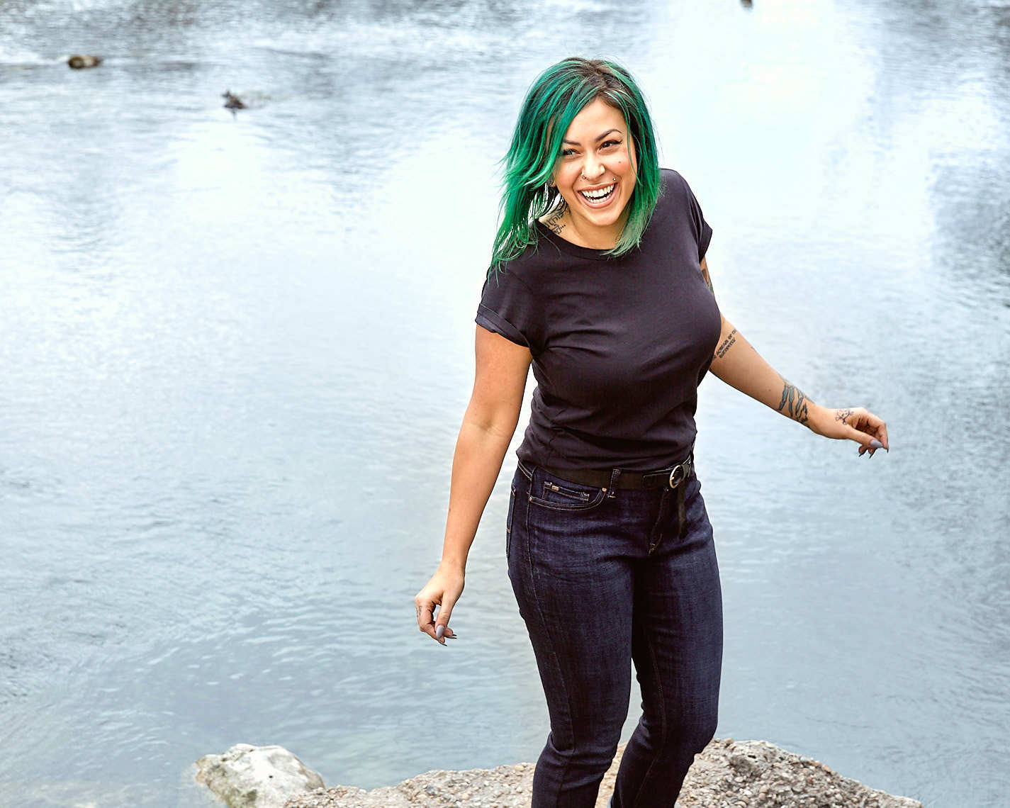 Woman with green hair Brianne Bachini smiling by a pond