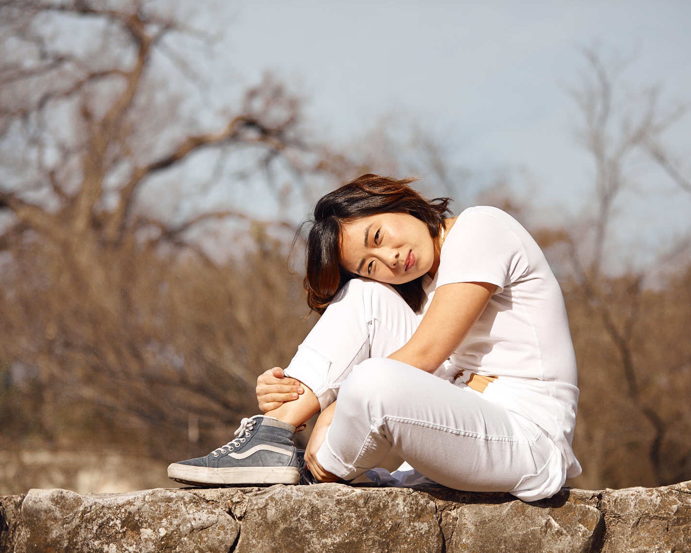 Woman Lauren Kayahara in white monochromatic outfit poses outdoors