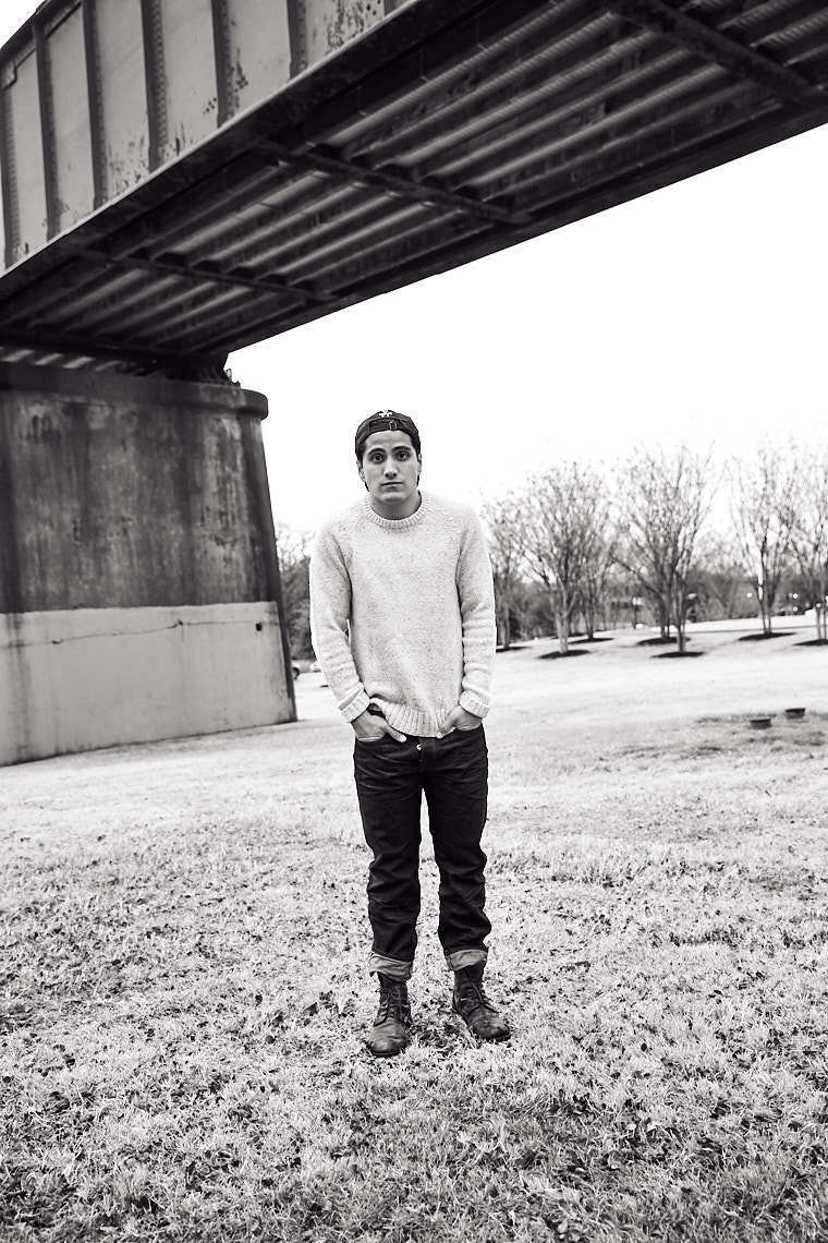 Black and white portrait of young man Rick Martinez in black jeans knit sweater