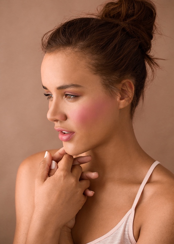 Beautiful portrait profile of tan brunette woman with pink blush