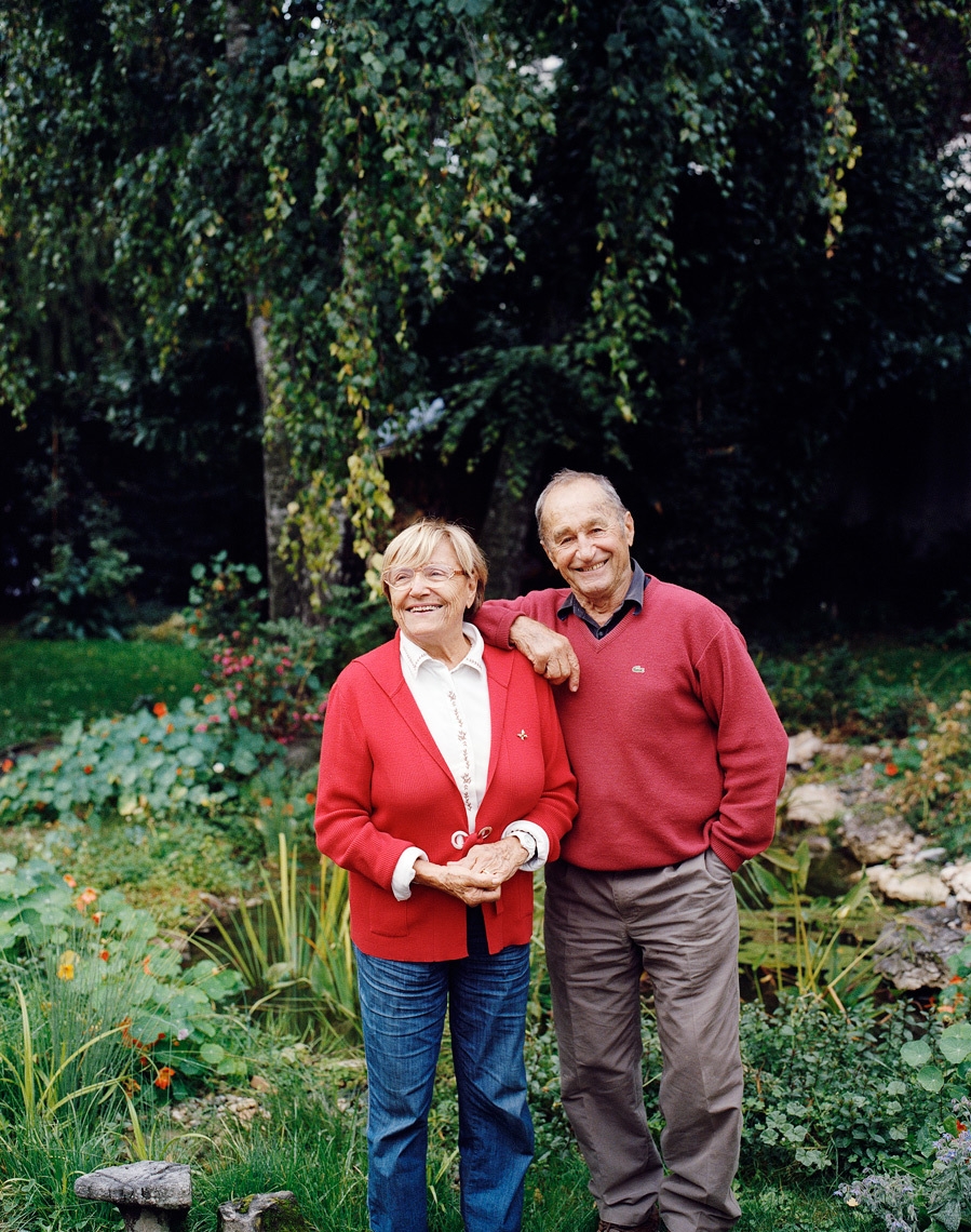 Portrait of happy older couple in garden with red sweaters