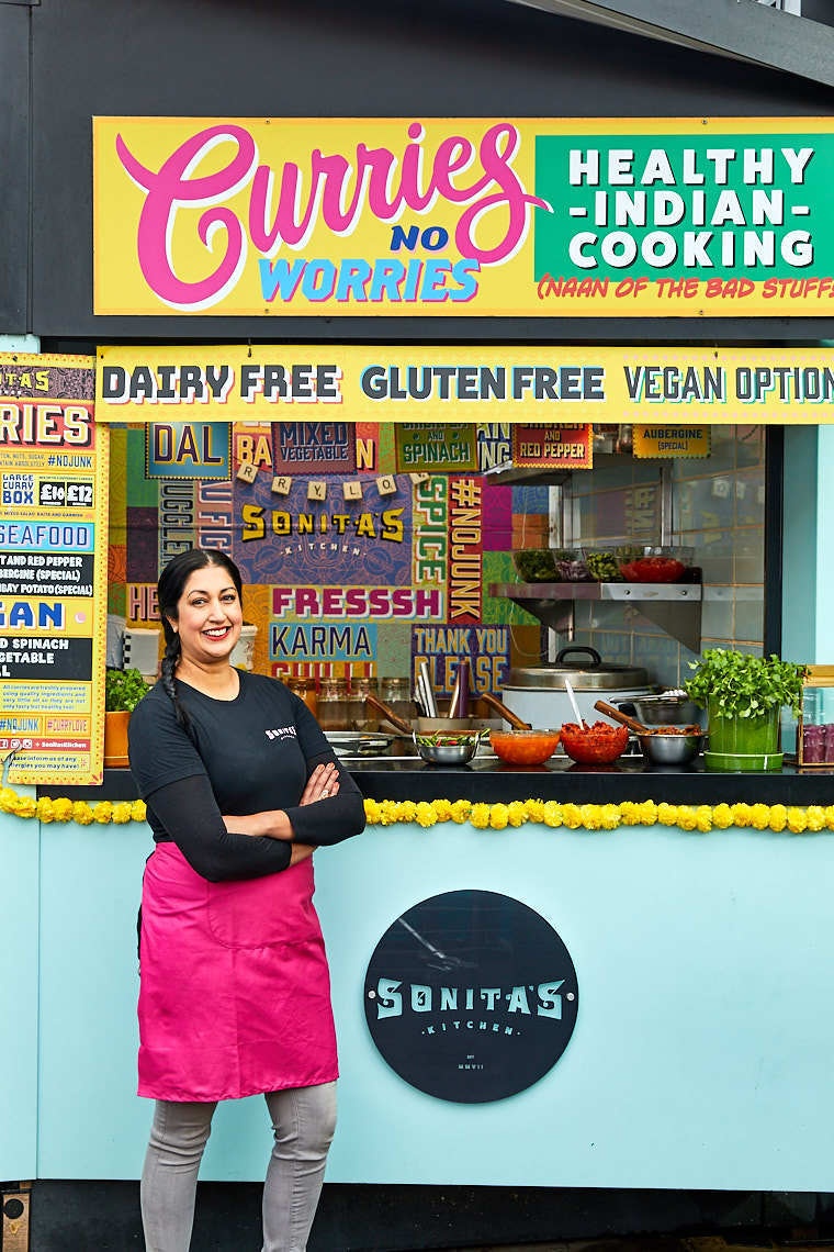 Female owner of Sonitas Kitchen standing in front of Indian food truck